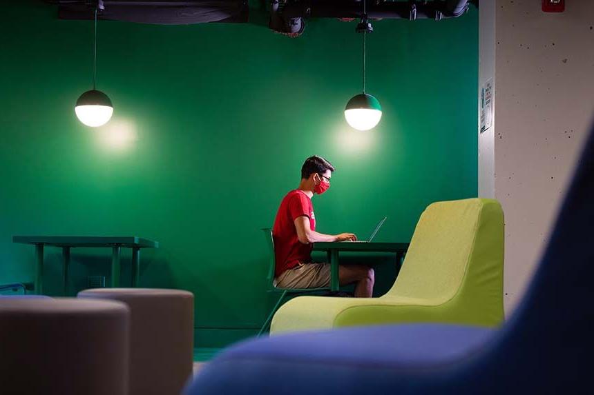 Kacek Hall Male Student Working on Computer in Lounge